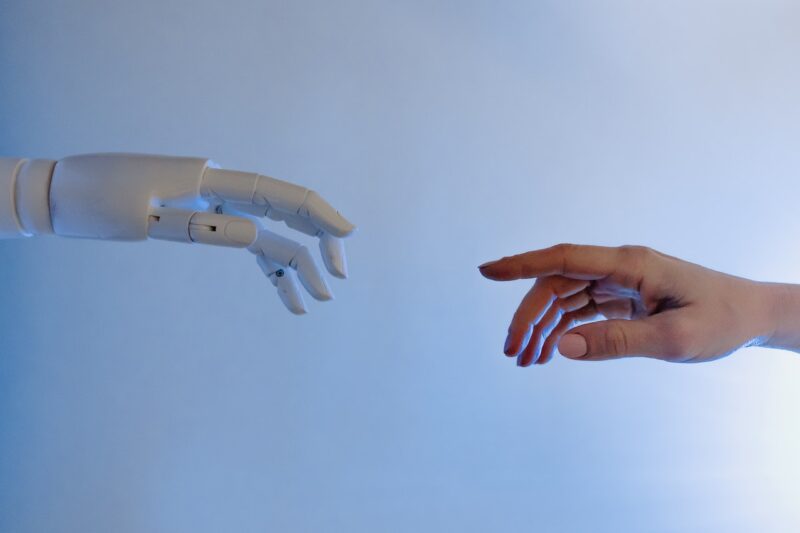 Hands of human and AI